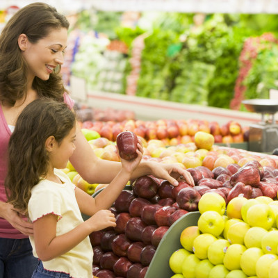 Mother and daughter shopping for fresh produce in supermarket